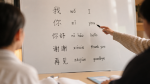Chinese language class with characters, pinyin and English on a whiteboard